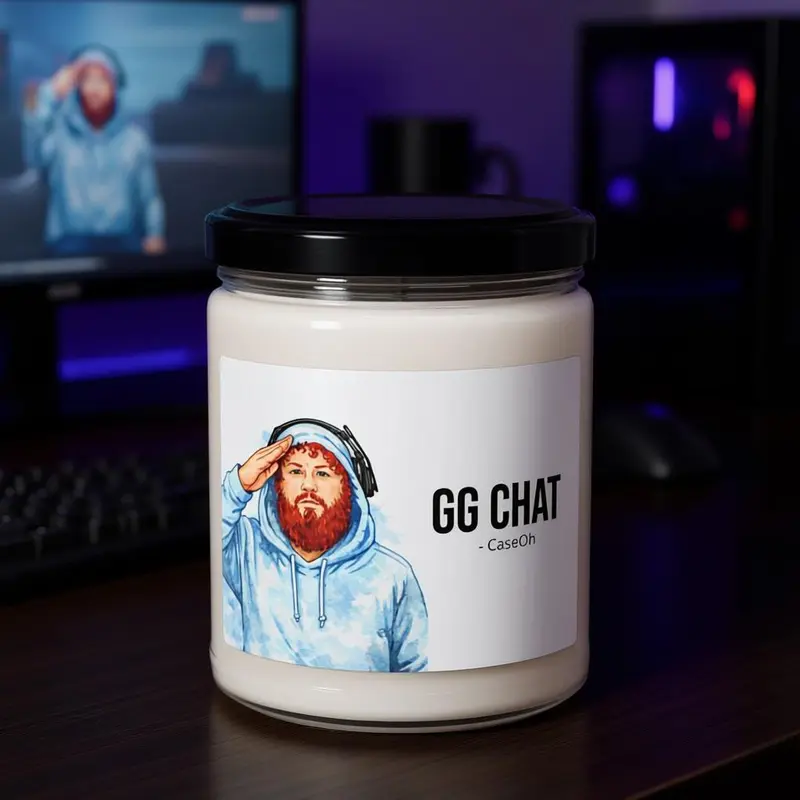 The GG Chat candle on a desk in front of monitors.
